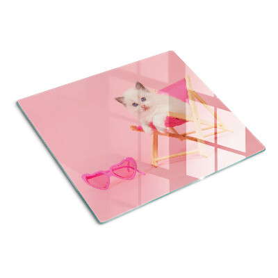 Tagliere in vetro Gattino su una sedia a sdraio su uno sfondo rosa