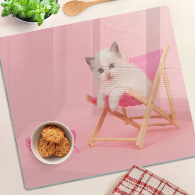 Tagliere in vetro Gattino su una sedia a sdraio su uno sfondo rosa