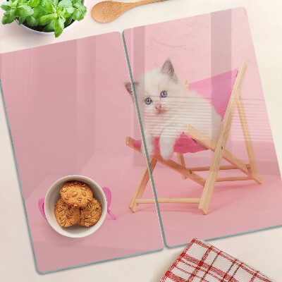 Tagliere in vetro Gattino su una sedia a sdraio su uno sfondo rosa