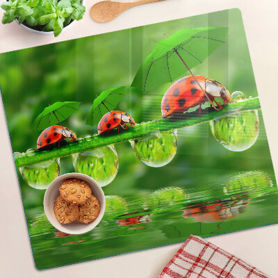 Tagliere in vetro Coccinelle sulle foglie con gocce d'acqua