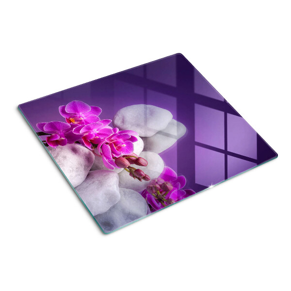 Tagliere in vetro Fiori di orchidea su uno sfondo di pietre