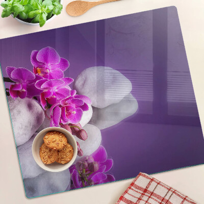 Tagliere in vetro Fiori di orchidea su uno sfondo di pietre