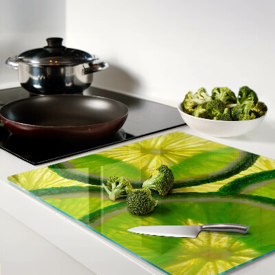 Tagliere in vetro temperato Fette di lime su sfondo verde