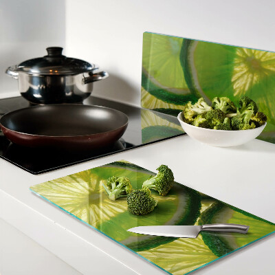 Tagliere in vetro temperato Fette di lime su sfondo verde