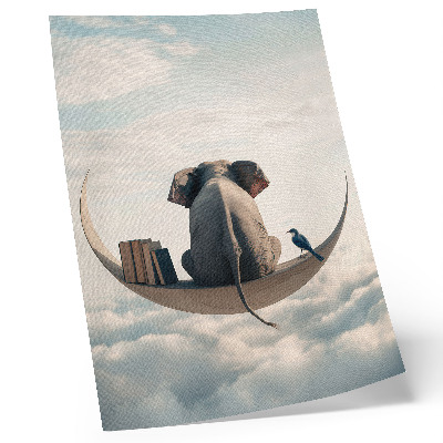 Foto su tela Un elefante su una falce di luna con libri tra le nuvole.