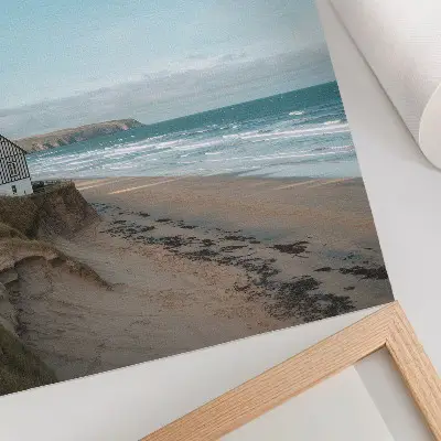 Stampa su tela spiaggia con onde e casa sulla scogliera nei toni pastello