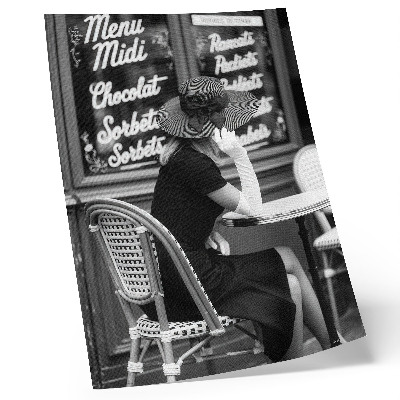Stampa su tela Una donna con un cappello seduta a un tavolo in un bar