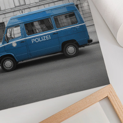 Stampa su tela Un'auto della polizia blu con un edificio sullo sfondo.
