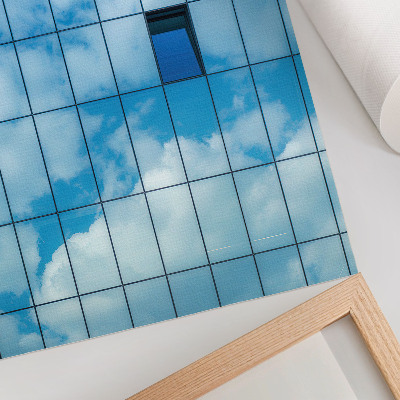 Poster Una facciata in vetro che riflette il cielo e le nuvole.