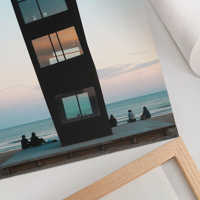 Poster Una moderna torre nera che si erge su un mare blu.