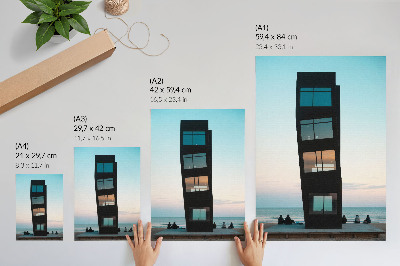 Poster Una moderna torre nera che si erge su un mare blu.