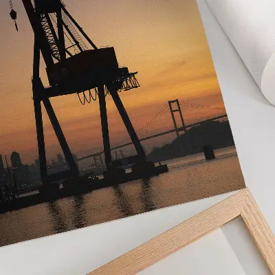 Poster silhouette di una gru industriale al tramonto su un ponte