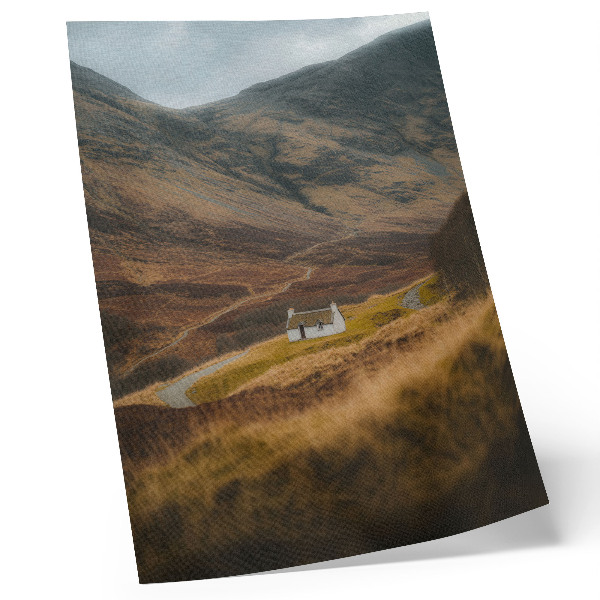 Foto su tela Un paesaggio montano con un cottage solitario in mezzo alla natura.