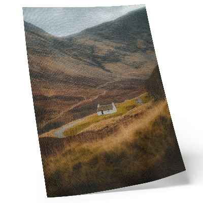 Foto su tela Un paesaggio montano con un cottage solitario in mezzo alla natura.