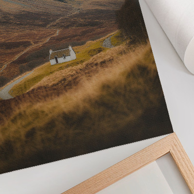 Foto su tela Un paesaggio montano con un cottage solitario in mezzo alla natura.