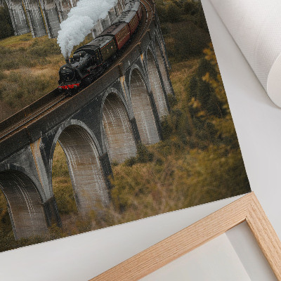 Stampa su tela Un treno su un ponte tra verdi colline