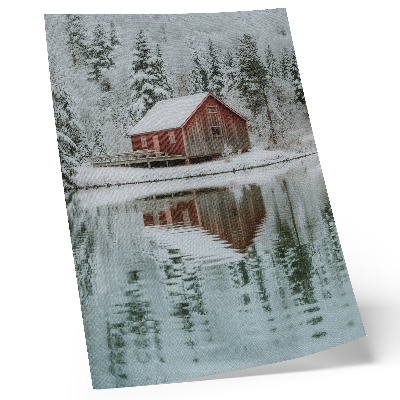 Poster Un cottage rosso tra alberi innevati in riva all'acqua