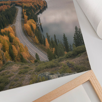 Foto su tela Una strada pittoresca tra gli alberi accanto al lago.