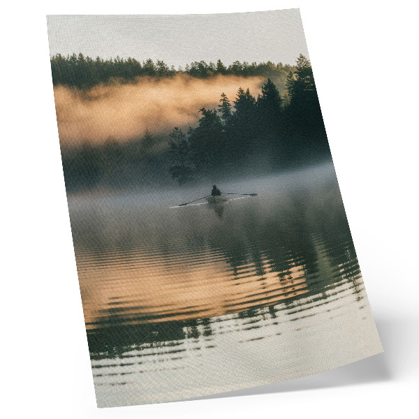 Foto su tela Barca avvolta nella nebbia sul lago, alberi verdi, riflessi sull'acqua.