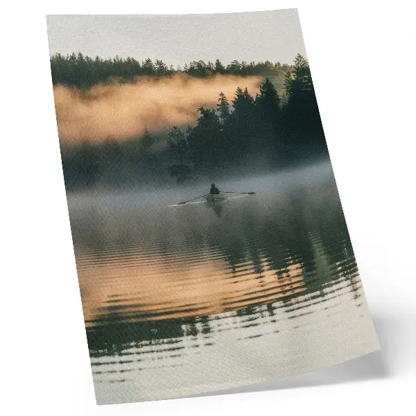 Foto su tela barca avvolta nella nebbia sul lago con alberi verdi e riflessi sull'acqua