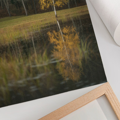 Poster Un albero dorato sullo sfondo di una foresta scura e di un lago.