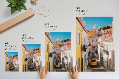 Stampa su tela Una strada con un tram, case popolari color pastello, fiori