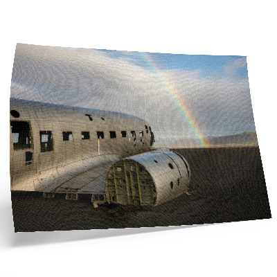 Poster dai colori saturi Il relitto di un aereo in metallo con un arcobaleno sullo sfondo.