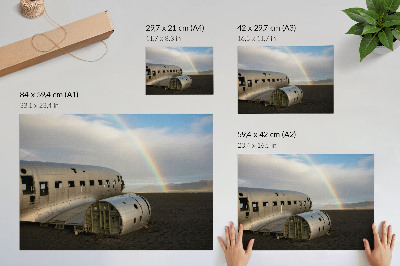 Poster dai colori saturi Il relitto di un aereo in metallo con un arcobaleno sullo sfondo.