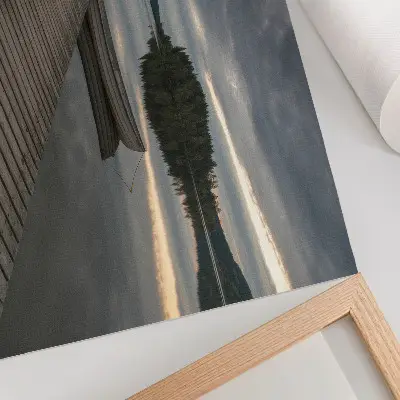 Poster con colori saturi raffigurante lago con barca, foresta e nuvole dall'atmosfera rilassante