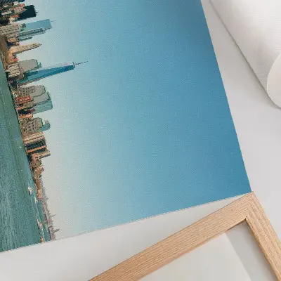 Poster grattacieli moderni sotto un cielo azzurro vicino all'acqua