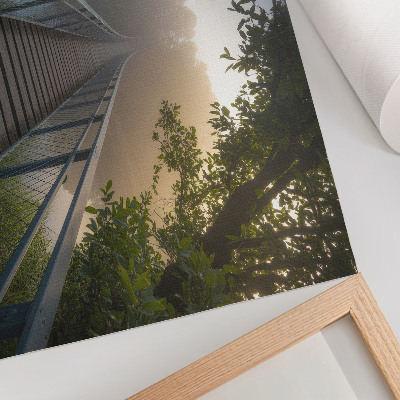 Poster dai colori saturi Un ponte nella nebbia su un fiume in un ambiente verdeggiante