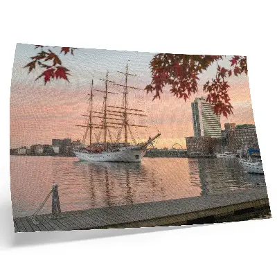 Poster con veliero al tramonto e tranquillo panorama cittadino