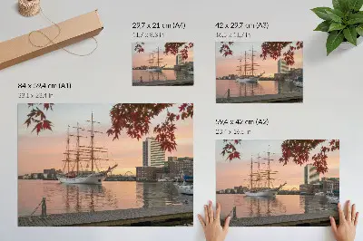 Poster con veliero al tramonto e tranquillo panorama cittadino
