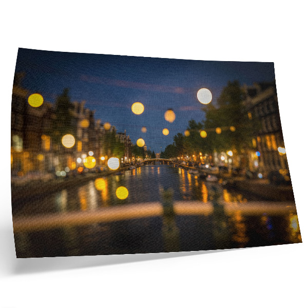 Poster dai colori saturi Una città incantevole di notte, con le luci riflesse nell'acqua.
