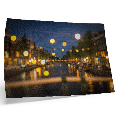 Poster dai colori saturi Una città incantevole di notte, con le luci riflesse nell'acqua.