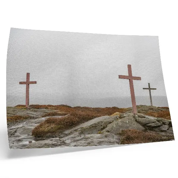 Poster tre croci di legno su una collina immersa nella nebbia