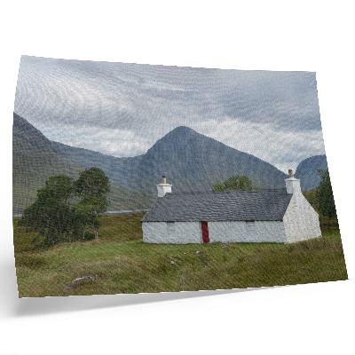 Stampa su tela moderna Un cottage bianco immerso tra montagne e vegetazione.