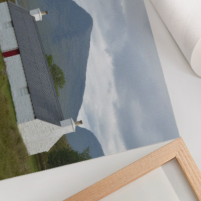 Stampa su tela moderna Un cottage bianco immerso tra montagne e vegetazione.