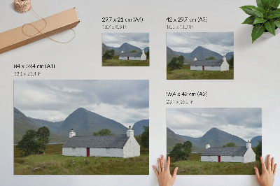 Stampa su tela moderna Un cottage bianco immerso tra montagne e vegetazione.