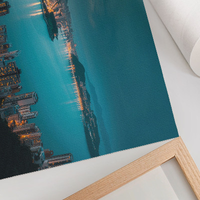 Poster dai colori saturi Vista notturna della città sull'acqua, grattacieli luminosi
