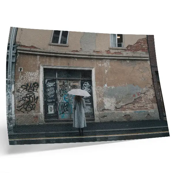 Poster murale di alta qualità persona con ombrello davanti a un muro con graffiti