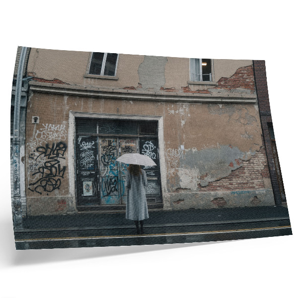 Poster murale di alta qualità Una persona con un ombrello davanti a un muro ricoperto di graffiti.