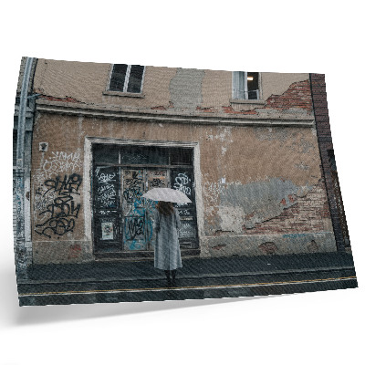 Poster murale di alta qualità Una persona con un ombrello davanti a un muro ricoperto di graffiti.