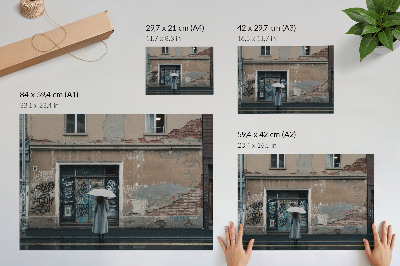 Poster murale di alta qualità Una persona con un ombrello davanti a un muro ricoperto di graffiti.