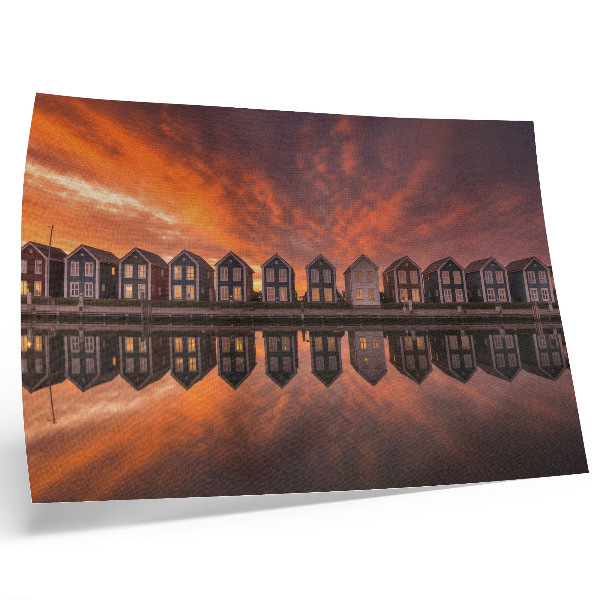 Poster Case colorate in riva al mare illuminate dalla luce del tramonto.