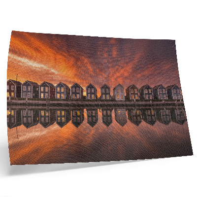 Poster Case colorate in riva al mare illuminate dalla luce del tramonto.