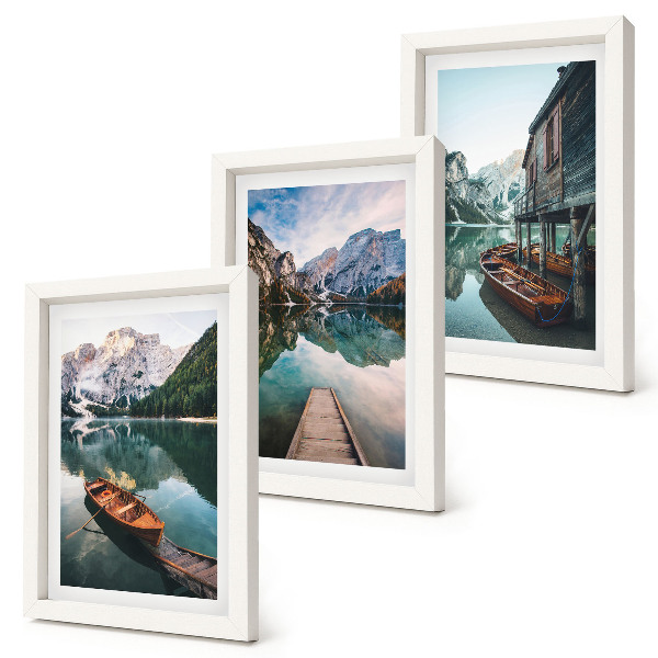 Trittico incorniciato Un lago di montagna con barche e una baita di legno.