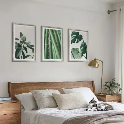 Composizione di quadri con steli di bambù e foglie di monstera